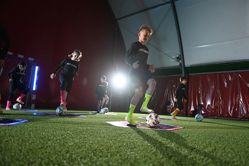 Young football players using IQ360 mats during a group training session